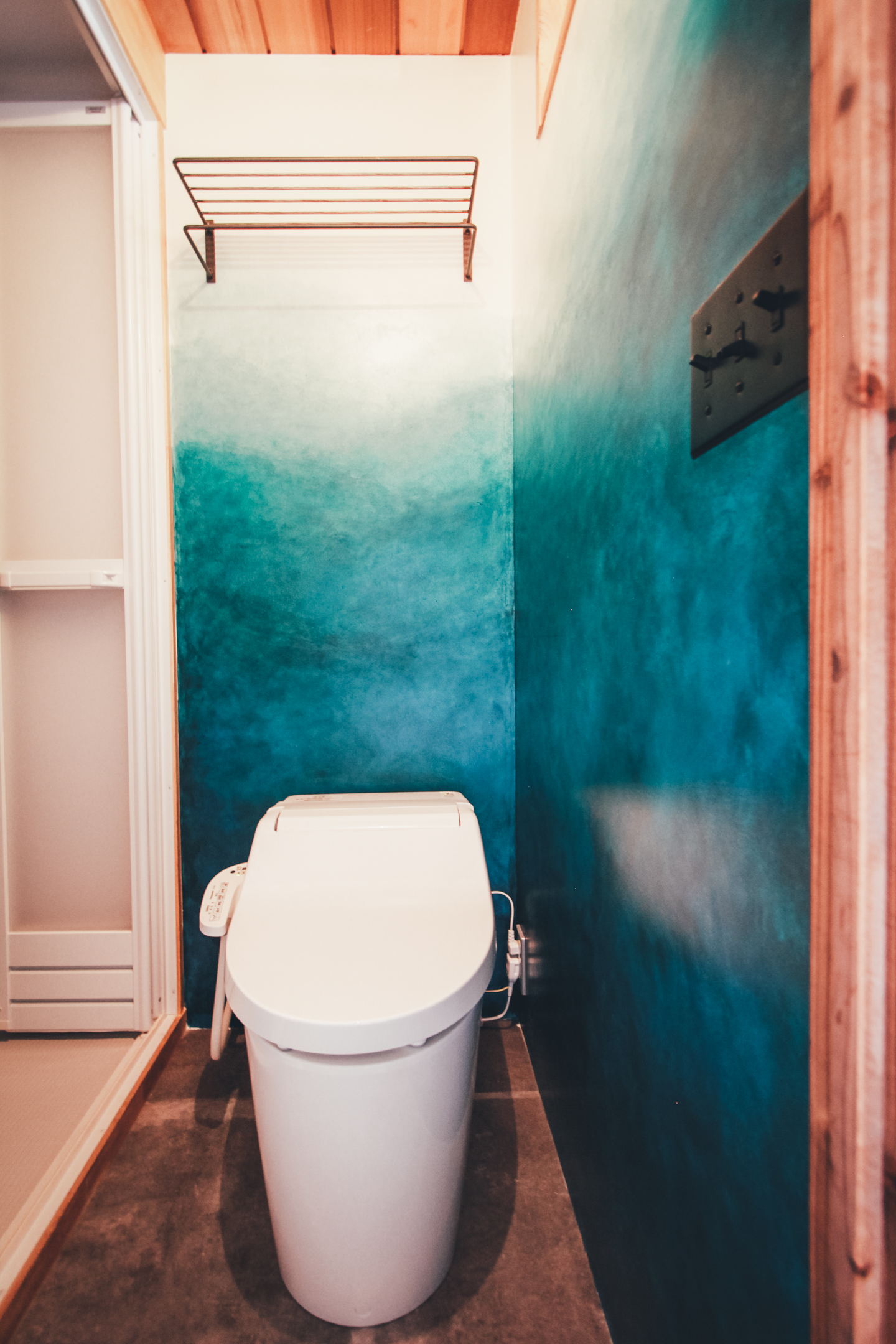 青色のグラデーションの壁のトイレ