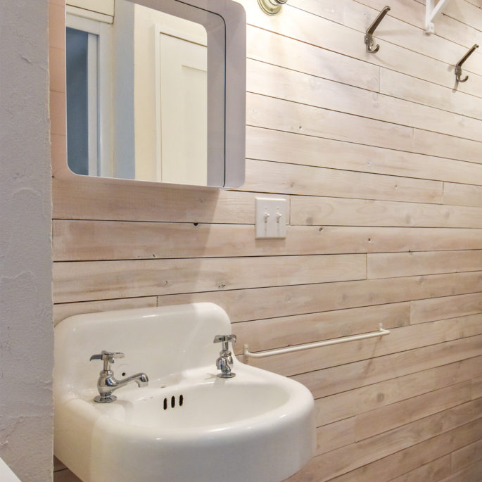 白塗装の木板の壁と手洗器