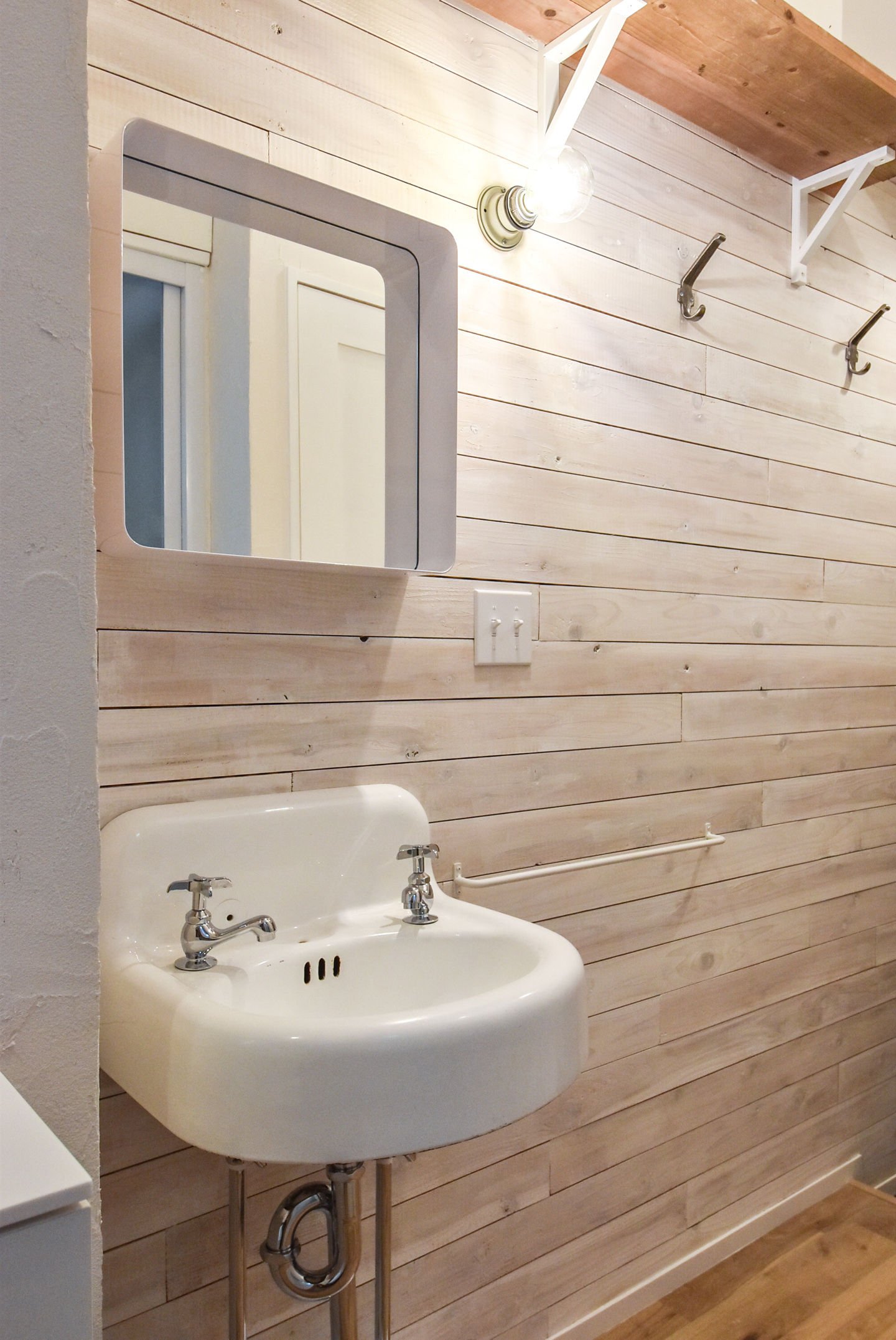 白塗装の木板の壁と手洗器